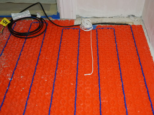 Electric radiant heating cable and membrane being installed in a tiny house. 