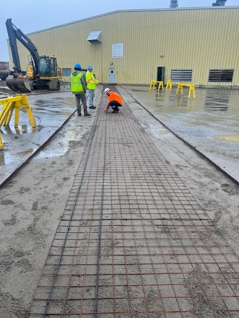 Installers working on laying out snow melt cables for a walkway.