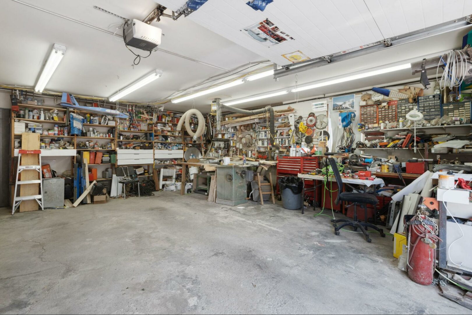 A heated garage with a cluttered workstation. A heated garage with a cluttered workstation.