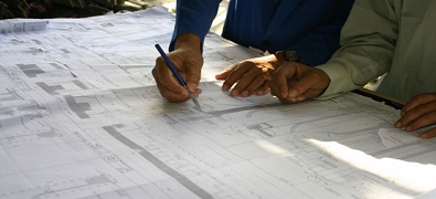 people drawing on construction plans