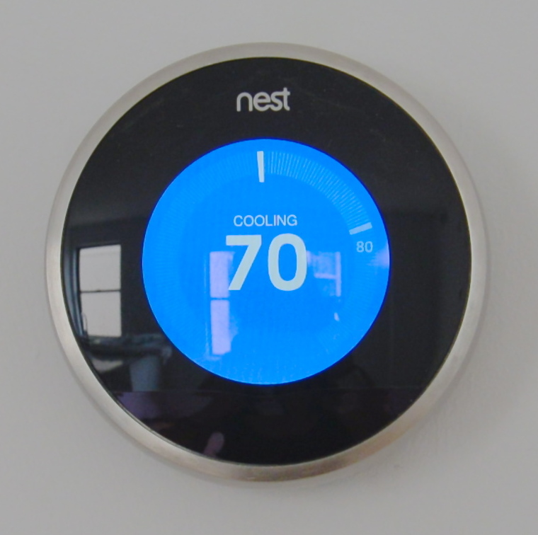 A Nest Thermostat on a wall, set to 70 degrees Fahrenheit. A Nest Thermostat on a wall, set to 70 degrees Fahrenheit.