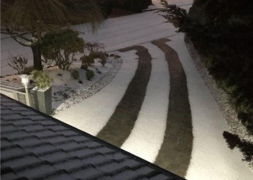 An icy driveway with radiant heated tire tracks.