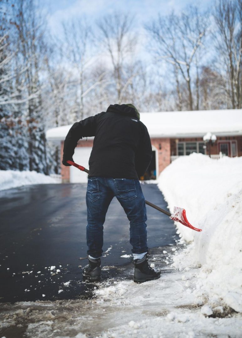A person shoveling snow off of a driveway.