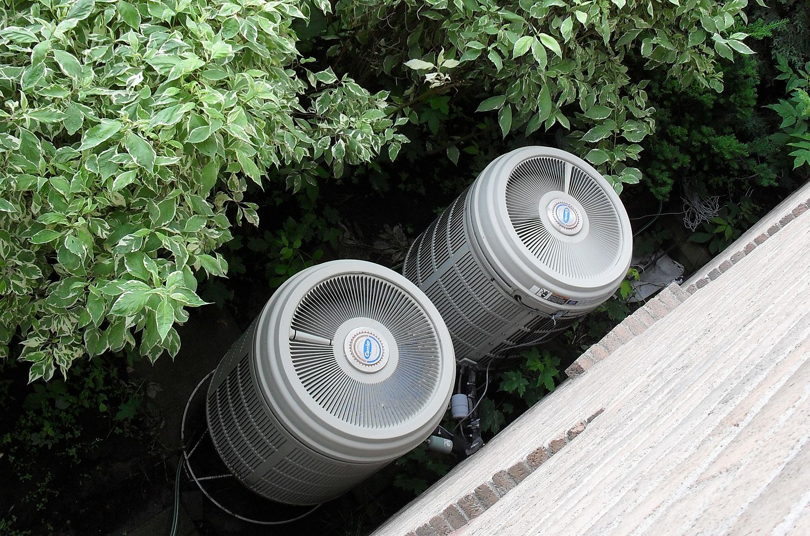 Two heat pumps outside of a house.