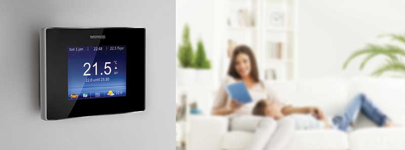 family in living room with Warmup smart thermostat